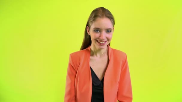 Счастливая позитивная женщина смеется в космической студии на желтом фоне — стоковое видео