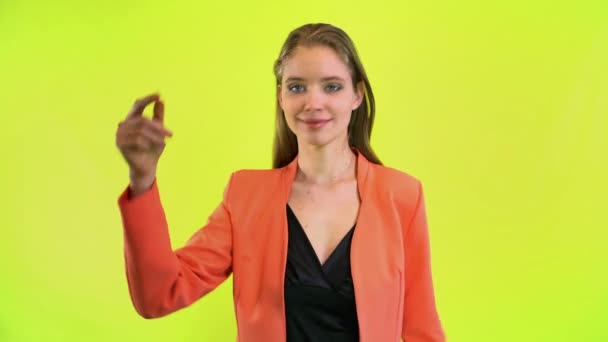 Женщина щелкает рукой и делает 10 волшебных снимков в желтой космической студии — стоковое видео