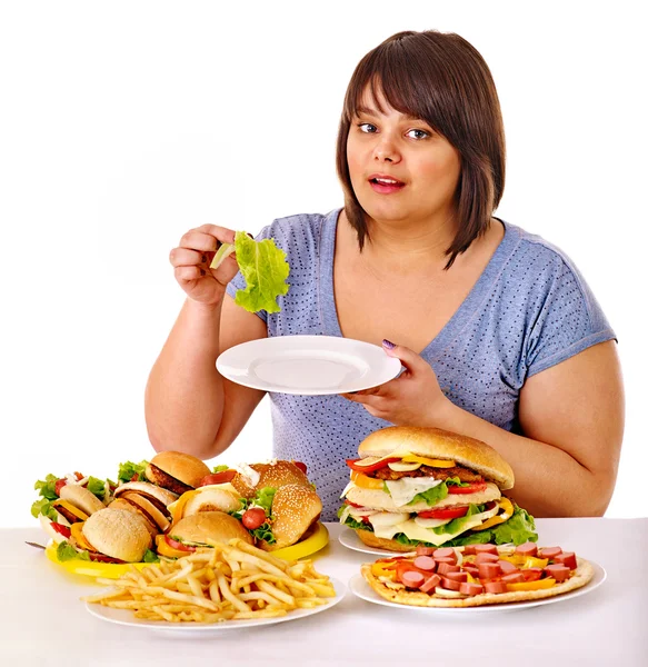 Mujer eligiendo entre fruta y hamburguesa . —  Fotos de Stock