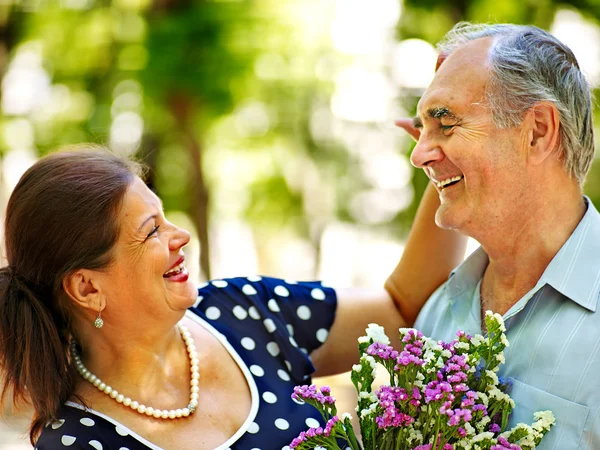 Gelukkige oude paar met bloem. — Stockfoto