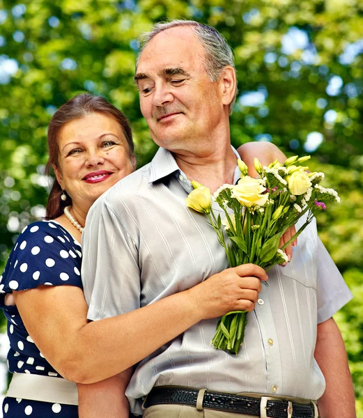 Gelukkige oude paar met bloem. — Stockfoto
