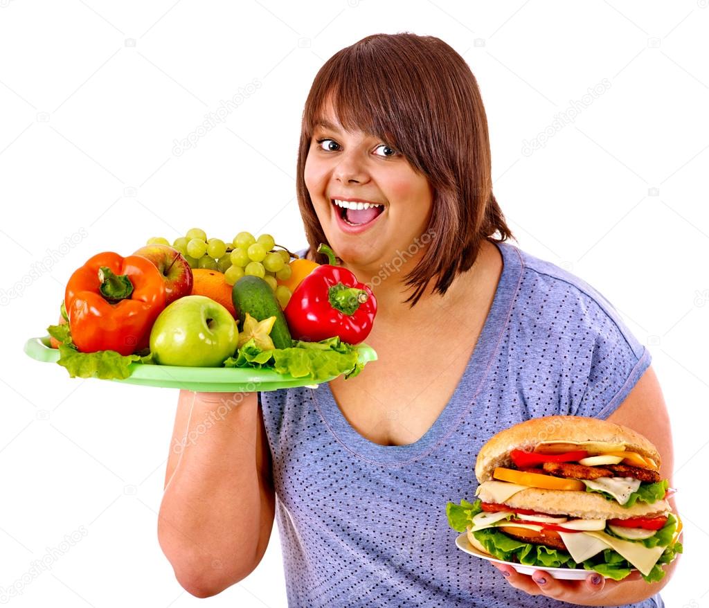 Woman choosing between fruit and hamburger.