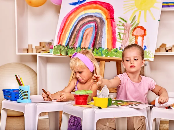 Children painting at easel. — Stock Photo, Image