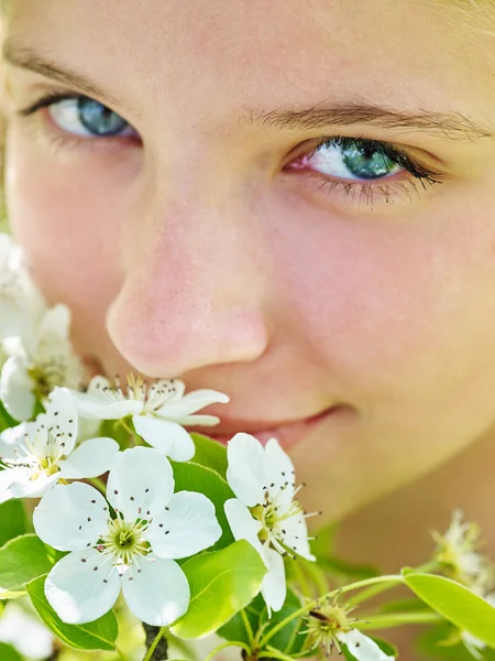 Girl touch face of flower on tree. — Stock Photo, Image