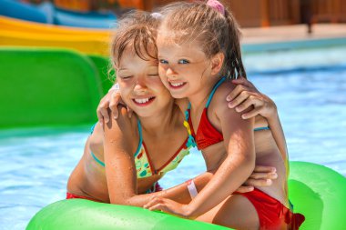 şişme halkada oturan çocuk.