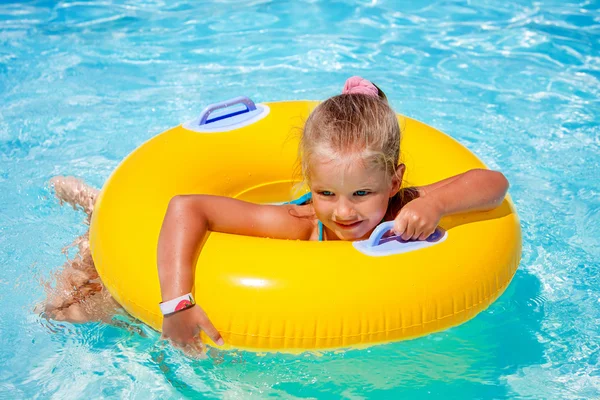 Kind op opblaasbare ring in zwembad. — Stockfoto