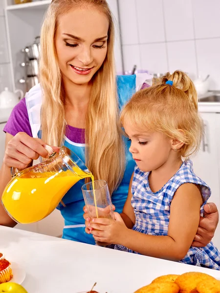 Mãe derramando suco para a filha — Fotografia de Stock