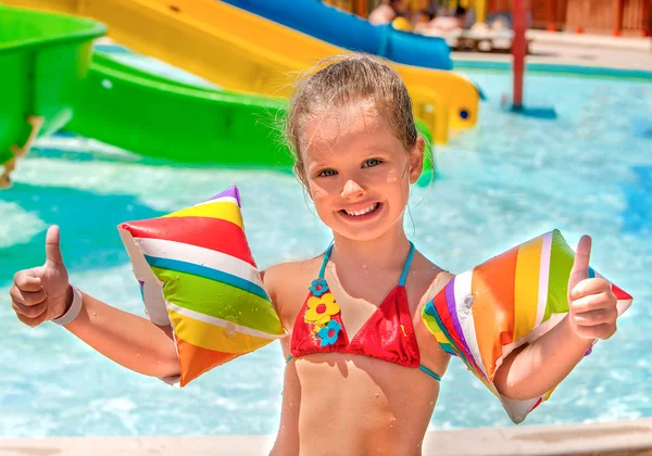 Criança com braçadeiras tocando na piscina . — Fotografia de Stock