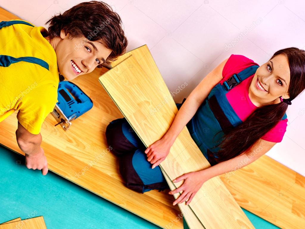 Family laying parquet at home.