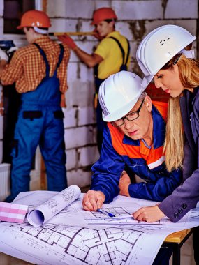 Business woman in helmet and  builders