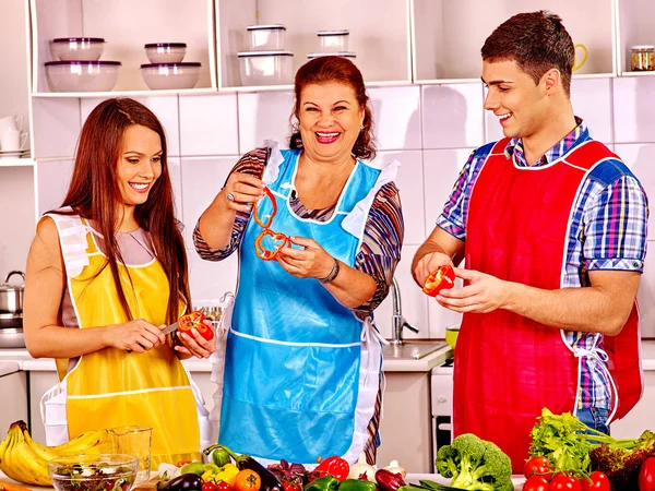 Mature woman with family preparing at kitchen. — Stock Photo, Image