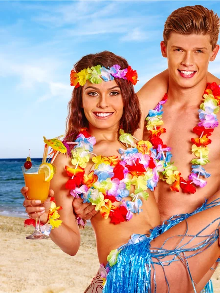 Met cocktail in hawaii krans strand (echt) paar. — Stockfoto