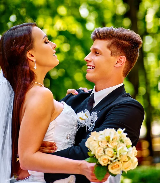 Mariée et marié avec des fleurs en plein air . — Photo