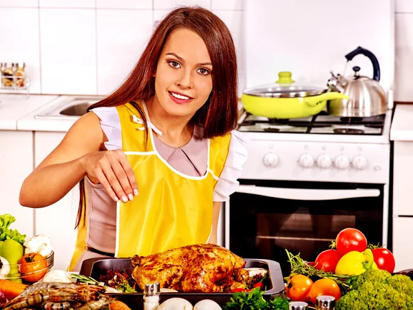 Mulher cozinha frango na cozinha . — Fotografia de Stock