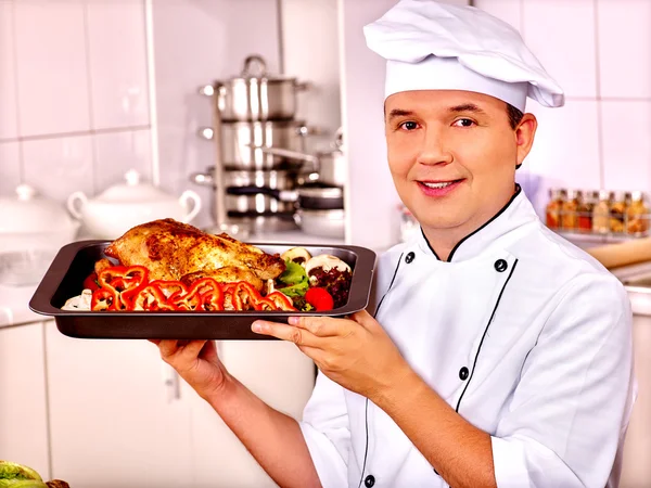 Człowiek w kapelusz kucharz gotuje kurczaka — Zdjęcie stockowe