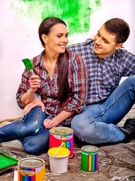 Family painting wall in green  at home.