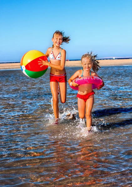 Children holding hands running on  beach. — Stock Photo, Image