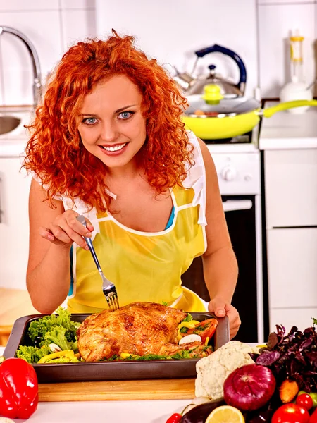 Donna che cucina pollo in cucina . — Foto Stock