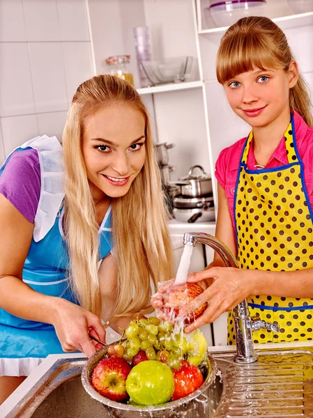 Famille avec enfant laver les fruits à la cuisine . — Photo