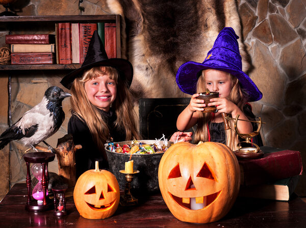 Witch children with pumpkin lantern.