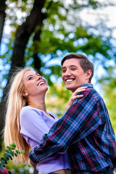 Jong koppel knuffelen en flirten in park. — Stockfoto