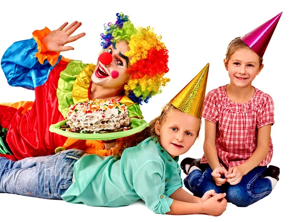 Clown holding cake on birthday with group children. Royalty Free Stock Images