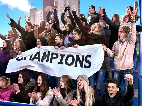 Fãs de esporte segurando banner campeão em tribunos . — Fotografia de Stock