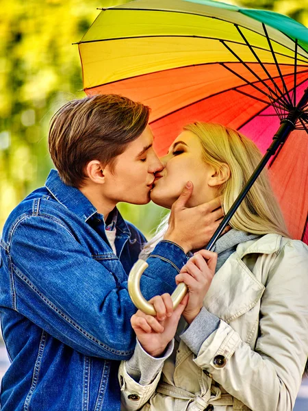 Pareja cariñosa en una cita besándose bajo paraguas . — Foto de Stock