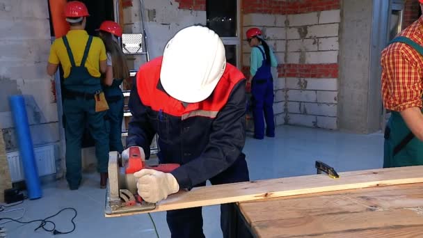 Hombre en casco constructor y uniforme con cepilladora eléctrica . — Vídeo de stock