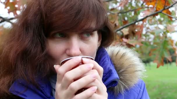 Vrouw drinken koffie in herfst park. Buiten — Stockvideo