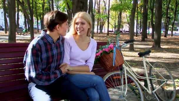 Paar mit Retro-Fahrrad im Park auf Bank. — Stockvideo