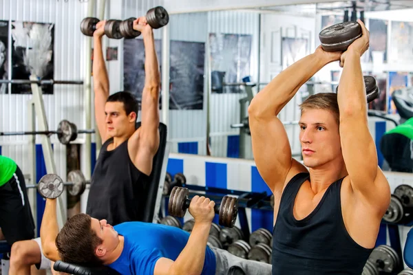 Gruppe von Männern bearbeitet seinen Körper im Fitnessstudio. — Stockfoto