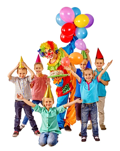 Payaso sosteniendo pastel y globos en cumpleaños con niños en grupo . — Foto de Stock