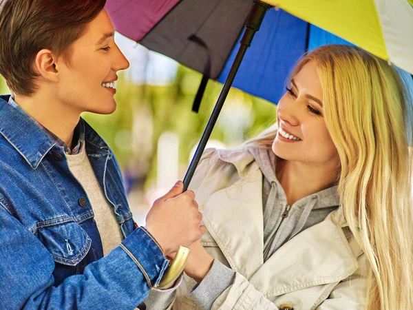 Pareja cariñosa hablando en una cita bajo paraguas . — Foto de Stock