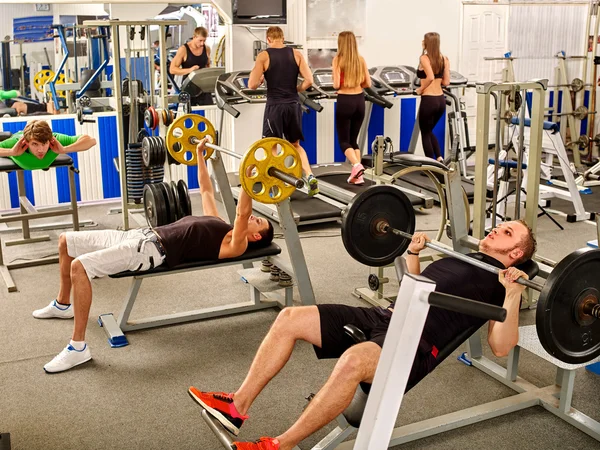 Gruppe von Menschen, die seinen Körper in einer großen Turnhalle bearbeiten. — Stockfoto