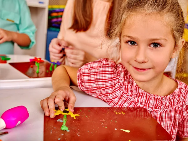 Meisje beeldhouwen van plasticine op Bureau in de kleuterschool . — Stockfoto