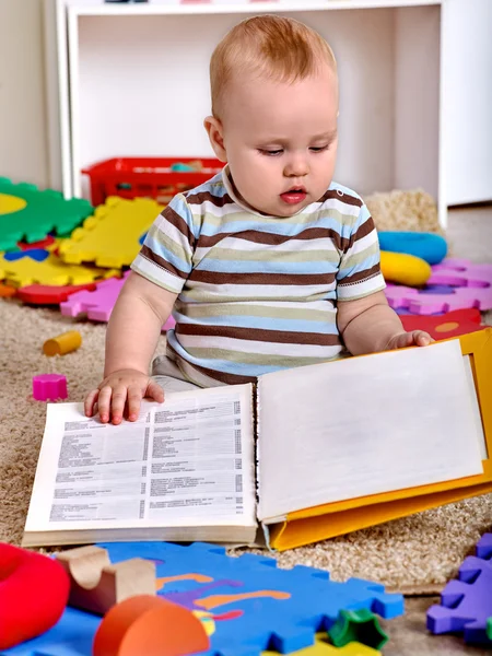 Niño niño niño sentado en el suelo y leyendo libro . — Foto de Stock