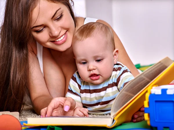 Criança com mãe lendo livro em casa . — Fotografia de Stock