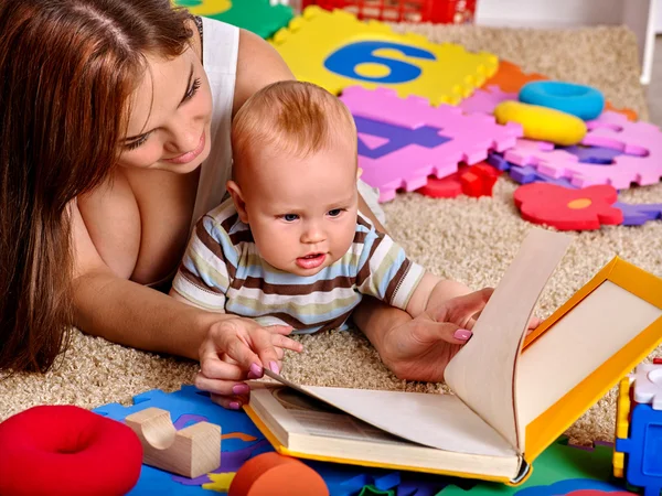 Criança menino com mãe dobrando brinquedo de quebra-cabeça no chão . — Fotografia de Stock