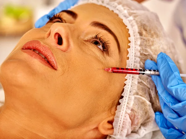 Kvinna medelålders i spasalong med kosmetolog. Kvinnan ger botox injektioner. — Stockfoto