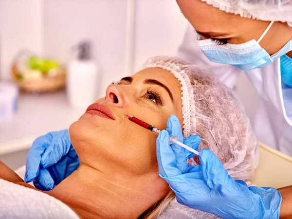 Mujer de mediana edad en el salón de spa con esteticista. Inyecciones de botox para mujeres . —  Fotos de Stock