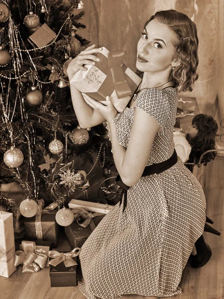 Frau öffnet Geschenk unter dem Weihnachtsbaum — Stockfoto