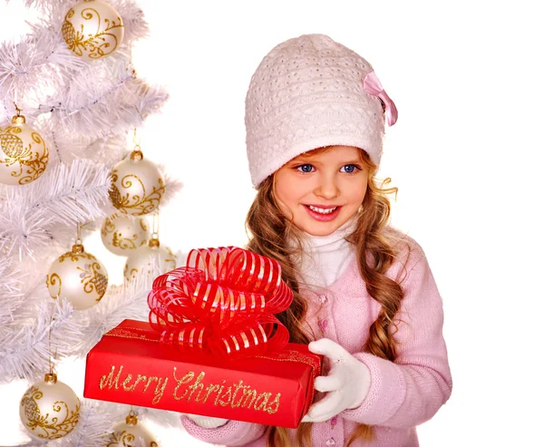 Παιδί κρατώντας δώρο κοντά χριστουγεννιάτικο δέντρο — Φωτογραφία Αρχείου