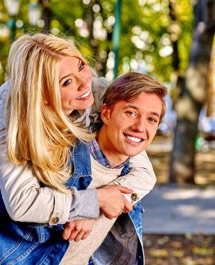 Genç çift parkta sarılıyor.