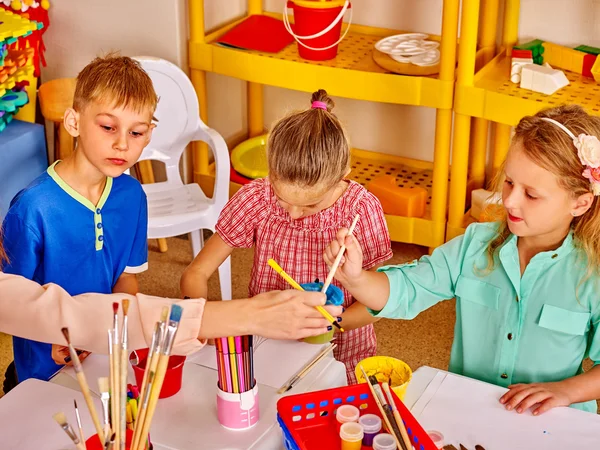 Mädchen mit Pinseln malen auf Tisch — Stockfoto