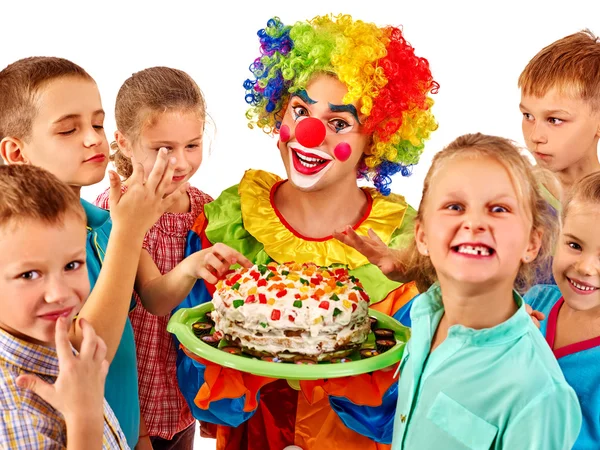 Clown holding cake and children — Stock Photo, Image