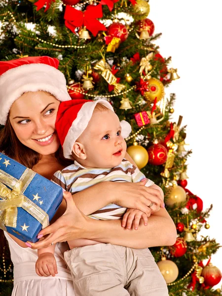 Mãe segurando bebê sob a árvore de Natal — Fotografia de Stock