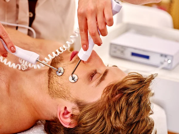 Homem recebendo descascamento facial elétrico — Fotografia de Stock