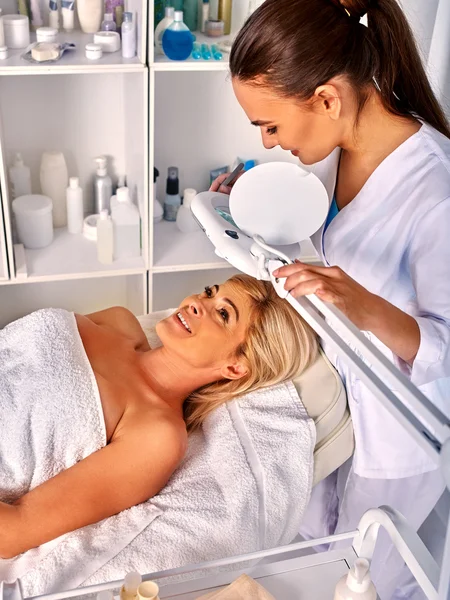 Frau im Wellness-Salon mit Kosmetiklampe — Stockfoto