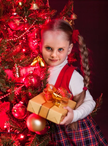 Criança com caixa de presente perto da árvore de Natal . — Fotografia de Stock